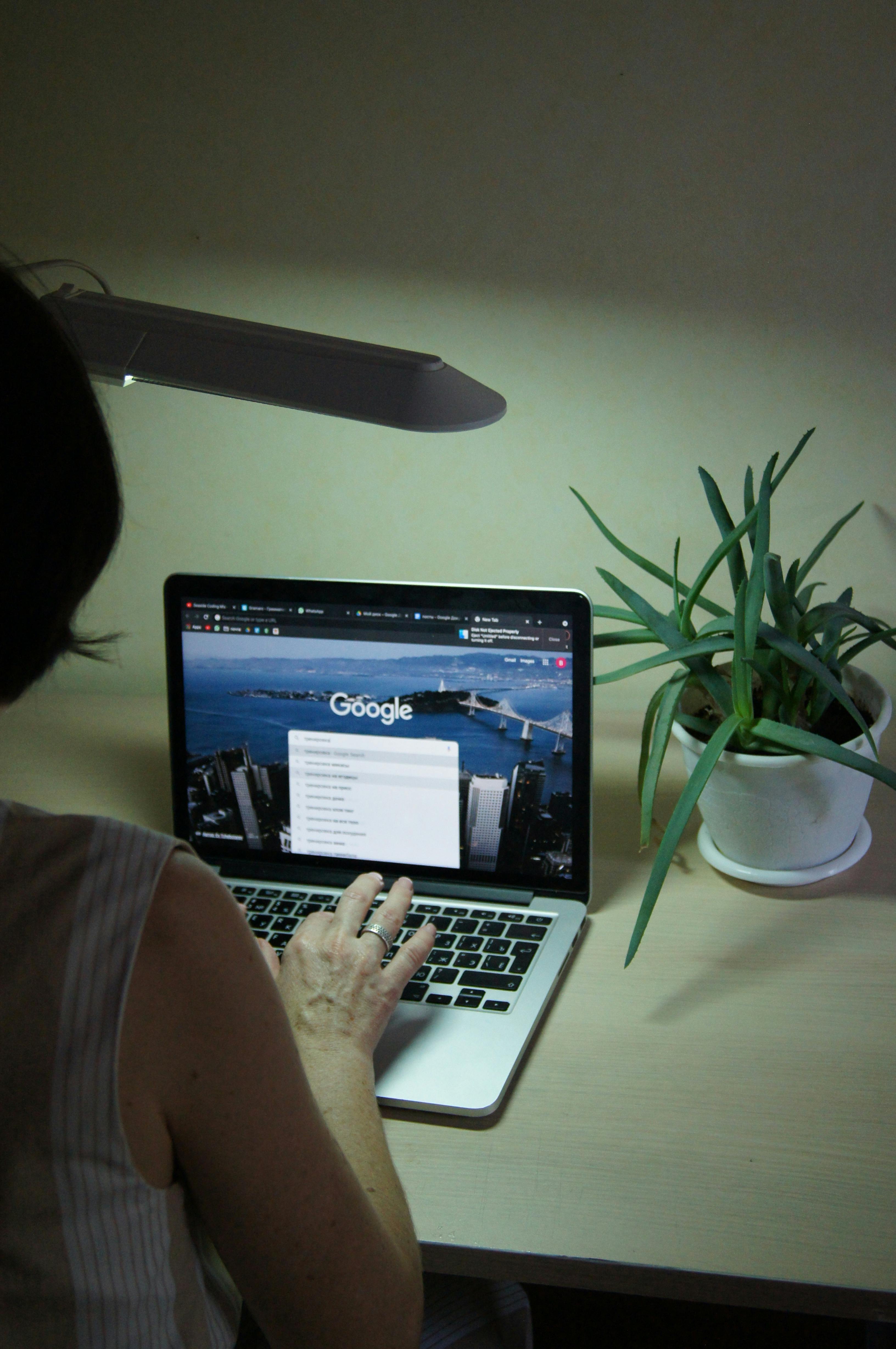 Lady sitting at her work station searching on Google.